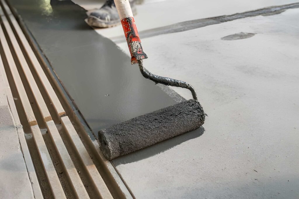 Manual worker installing non slip surface on the floor next to the drain gully