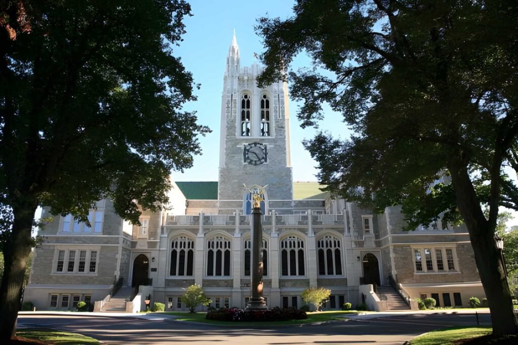 Modern glass science building on a grassy hill.