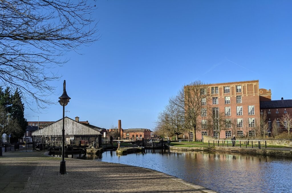 Canal view with paved path and brick building.