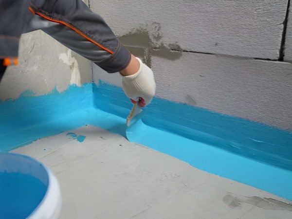 The waterproofing coating is blue. Cover the concrete wall with a cement-polymer waterproofing membrane. Waterproofing with a blue shade brush.
